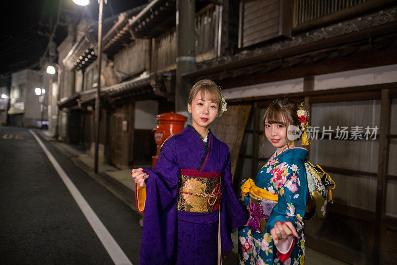 在“Seijin Shiki”成人礼之夜，身着Furisode和服的年轻女性参观日本传统村庄